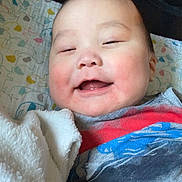 Colton joined the competition — help win amazing prizes! baby, smiling, blanket, child, face, cheeks, clothing, fabric, quilt, pattern, soft, cute, infant, happy, lying_down, indoor, portrait, head, toddler, skin