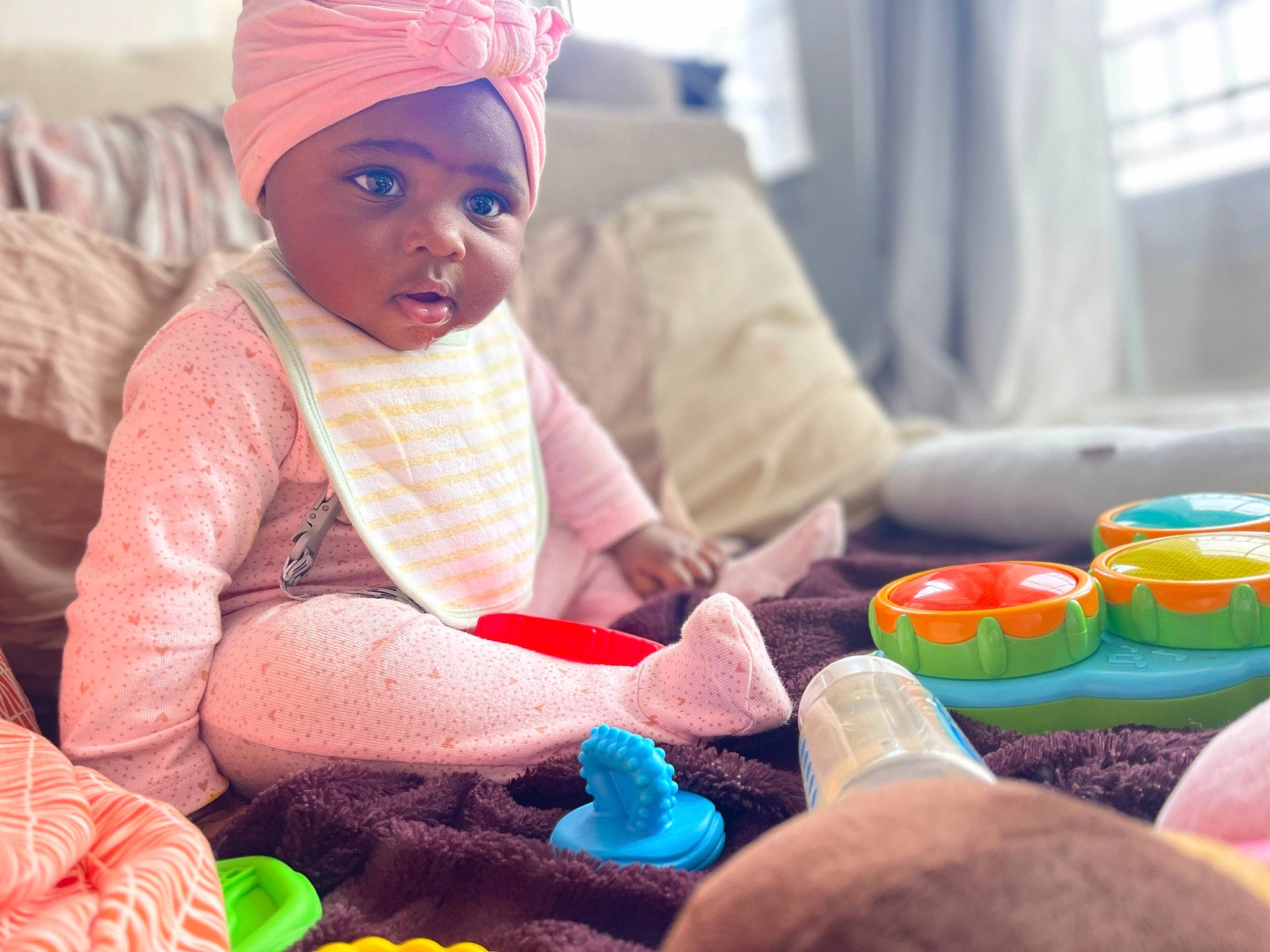 Lacey is registered to the contest to win money with this photo: baby, baby_toddler_clothing, child, comfort, curtain, finger, fun, green, headwear, human, linens, morning, pattern, person, play, room, sitting, sweetness, textile, toddler