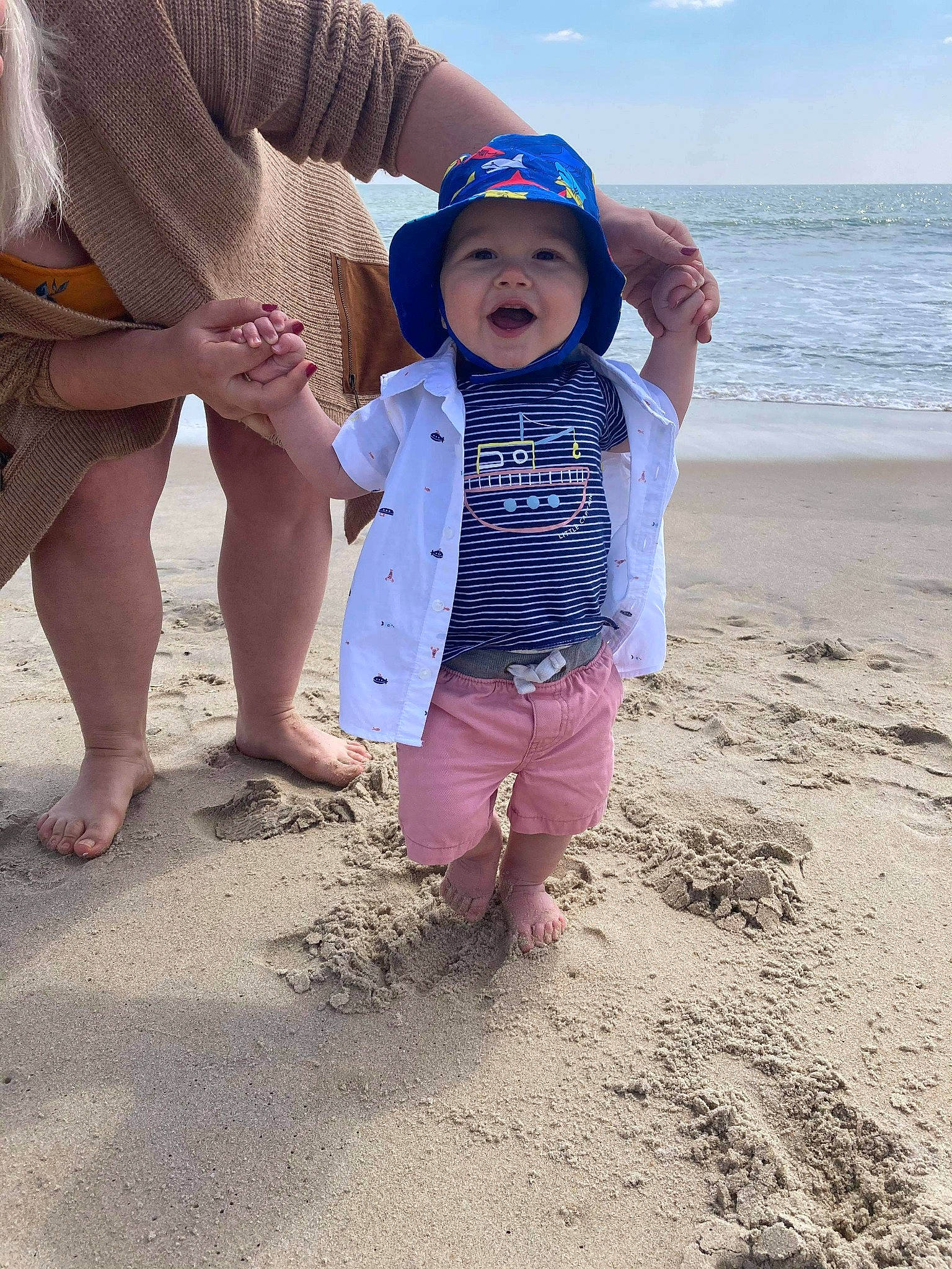 Jackson Thomas is registered to the contest to win money with this photo: baby, barefoot, beach, child, cloud, fun, gesture, hand, happy, hat, headwear, leg, leisure, people_in_nature, people_on_beach, person, sand, shorts, sky, sun_hat