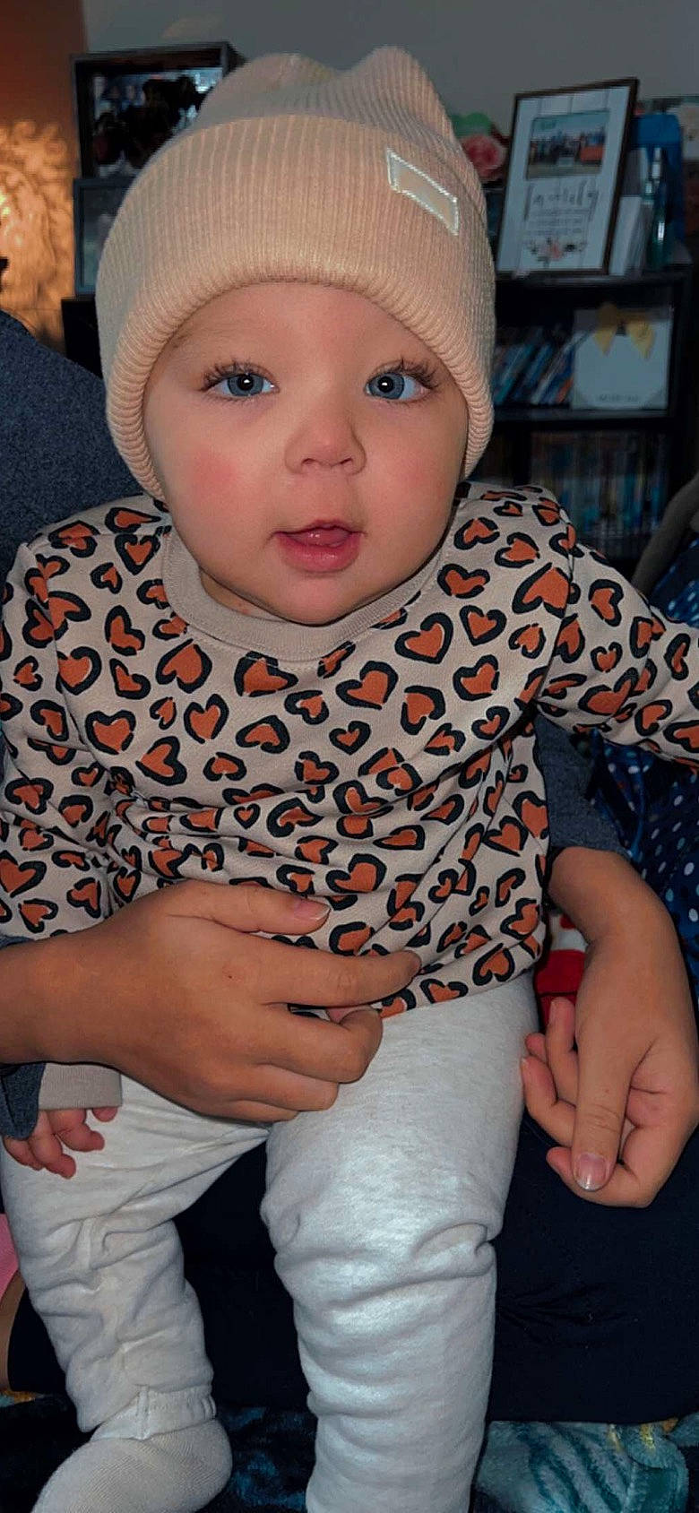 Estella is registered to the contest to win money with this photo: baby, baby_toddler_clothing, cap, cheek, child, cool, eye, finger, fun, happy, head, headgear, headwear, human, knit_cap, pattern, person, sitting, skin, sleeve