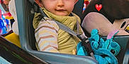 Tiago a rejoint le concours — aidez-le/la à gagner de superbes lots ! toddler, child, amusement_ride, seatbelt, plush_toy, blue_eyes, carnival, stars, ride_car, jacket, striped_shirt, indoor, colorful, face, expression, toy, seat, helmet, fun, entertainment