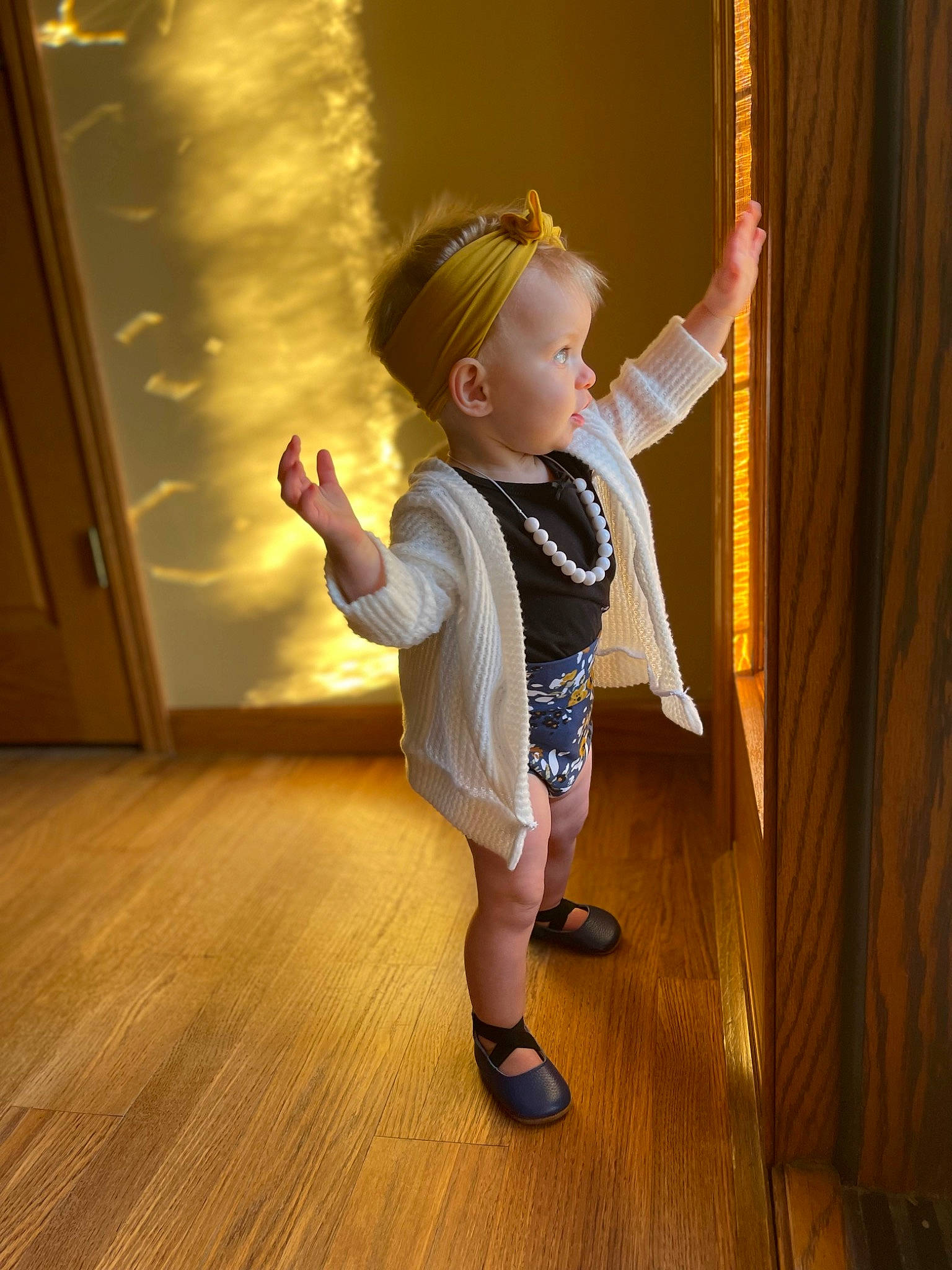 Jocelyn is registered to the contest to win money with this photo: baby_toddler_clothing, child, curtain, floor, flooring, foot, fun, gesture, happy, hardwood, human_leg, joint, laminate_flooring, person, t_shirt, toddler, trunk, varnish, wood, wood_flooring