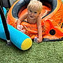 toddler, child, inflatable_pool, outdoor, grass, toy, plastic_cup, wet_hair, smiling, summer, play, blue, yellow, orange, bare_chest, happy, fun, daylight, recreation, backyard