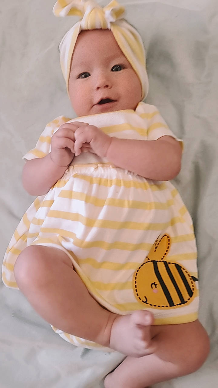 Joycelynn is registered to the contest to win money with this photo: arthropod, baby, baby_toddler_clothing, butterfly, comfort, finger, gesture, happy, insect, pattern, person, pink, pollinator, product, skin, sleeve, smile, thumb, toddler, white