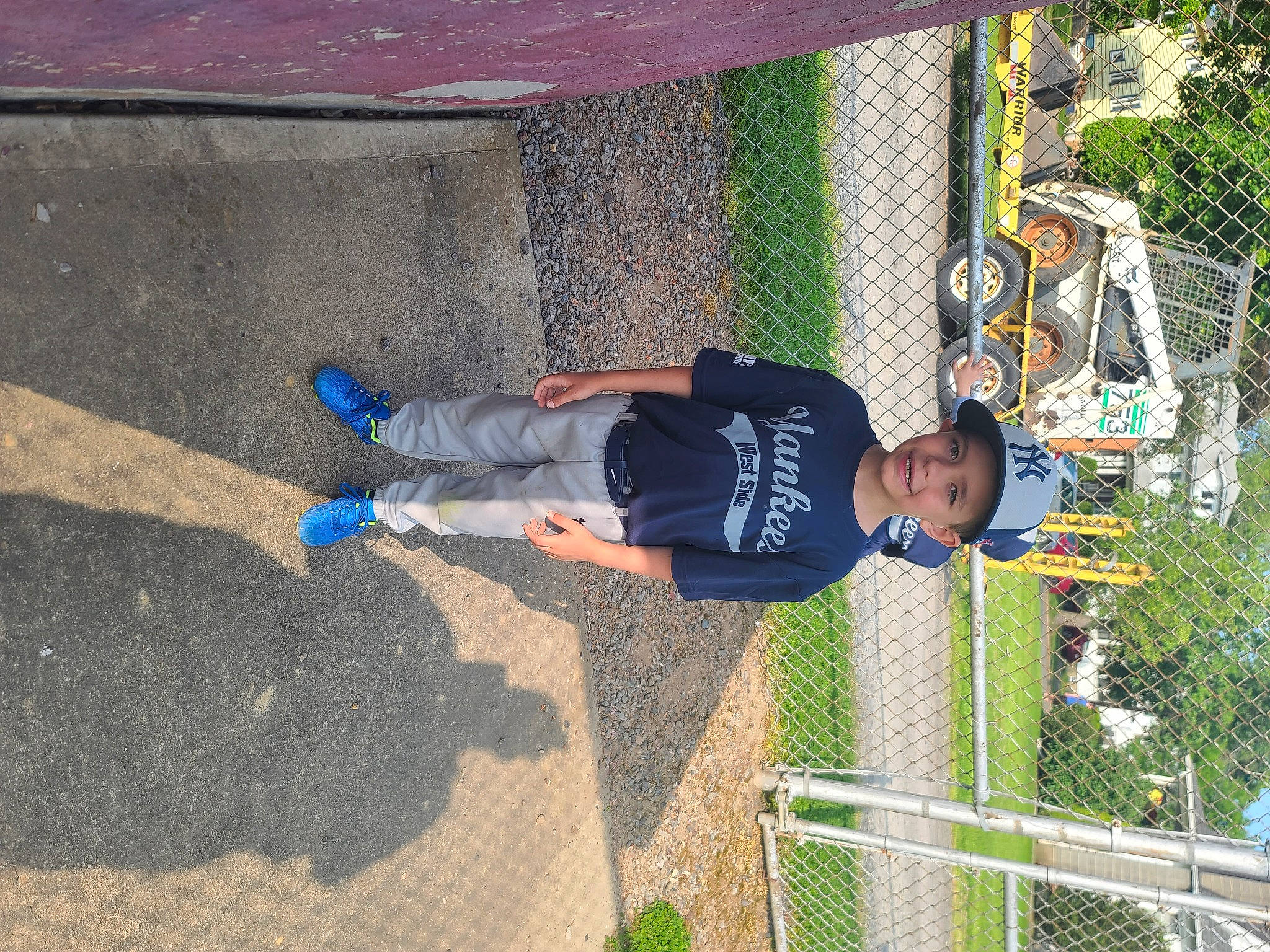 Christopher is registered to the contest to win money with this photo: asphalt, concrete, fence, fun, grass, headwear, joy, leisure, line, mesh, net, outdoor_play_equipment, person, plant, play, recreation, soil, sports, t_shirt, toddler