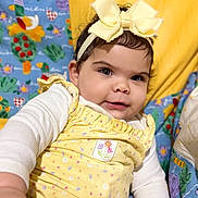 Shaddai joined the competition — help win amazing prizes! baby, child, yellow_bow, headband, yellow_outfit, cute, smiling, reaching_hand, colorful_background, patterned_fabric, portrait, infant, happy, indoors, closeup, face, clothing, person, playful, bright_colors