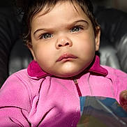 Shaddai joined the competition — help win amazing prizes! baby, blue_eyes, child, close_up, colorful_package, curly_hair, cute, face, holding_object, indoor, jacket, natural_light, person, pink_fleece, portrait, serious_expression, soft_light, toddler, warm_clothing, young_child