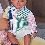 Monty joined the competition — help win amazing prizes! baby, child, striped_shirt, shorts, sandals, person, sitting, indoor, couch, hand, face, portrait, cute, infant, casual_clothing, multicolor, young_child, relaxed, people, skin