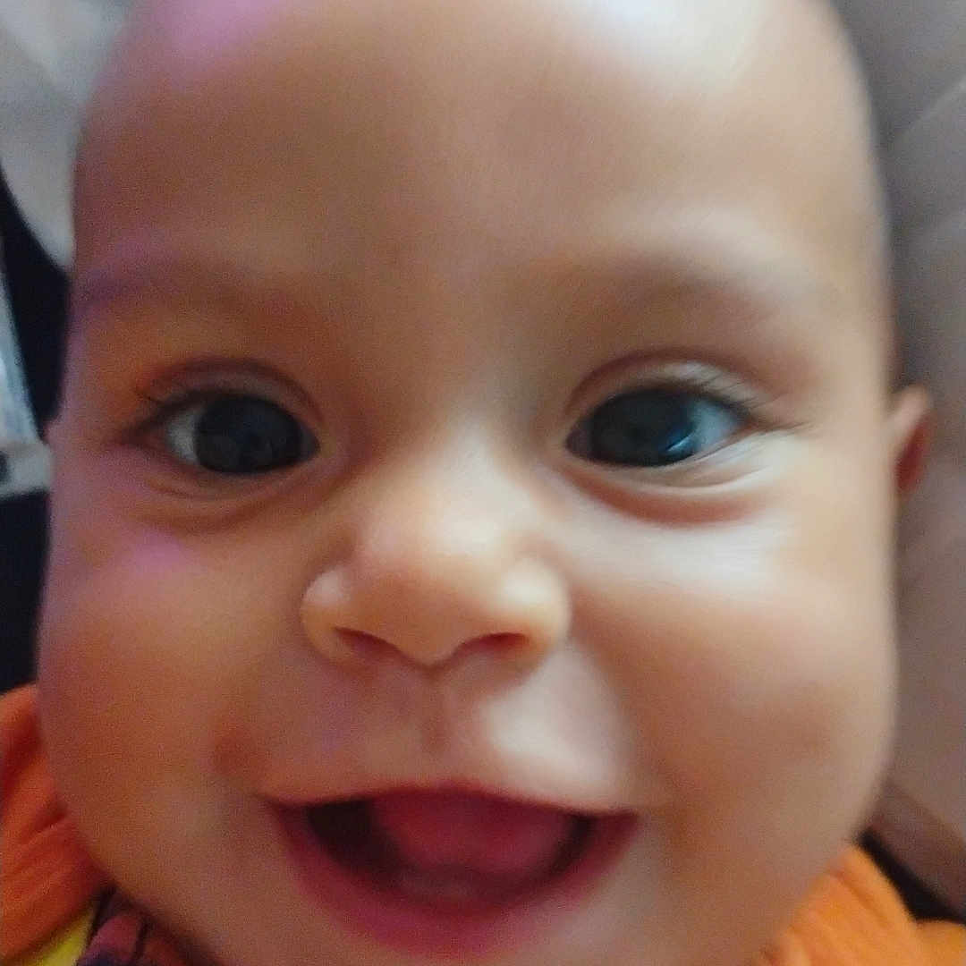 Bellamy is registered to the contest to win money with this photo: baby, cheeks, child, closeup, clothing, cute, expression, eyes, face, happy, head, infant, joyful, mouth, orange, person, portrait, skin, smile, young