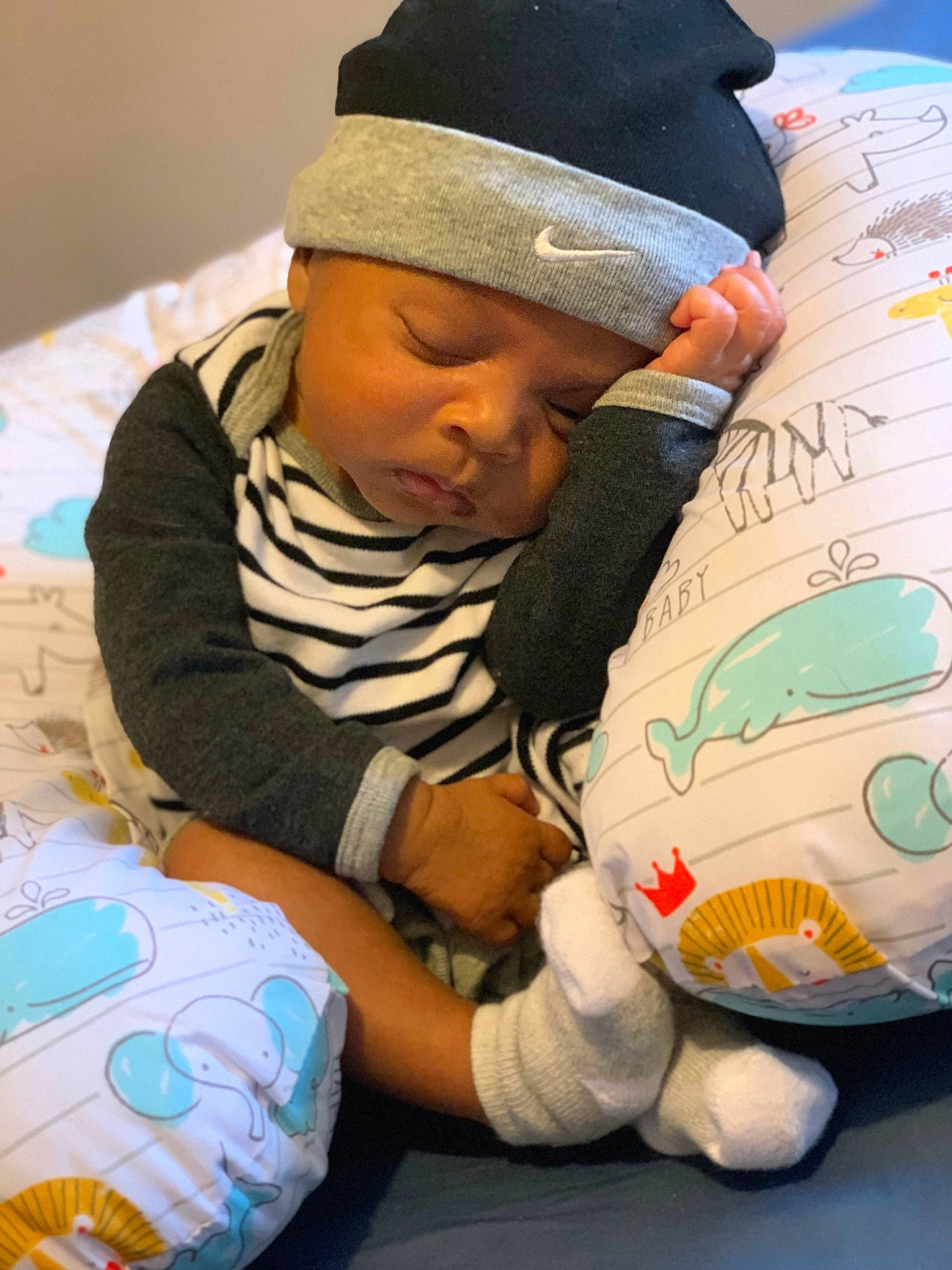 Zakai is registered to the contest to win money with this photo: baby, baby_products, baby_sleeping, baby_toddler_clothing, beanie, bedtime, cap, child, comfort, fun, headwear, knit_cap, linens, mammal, people, person, play, room, sitting, t_shirt