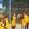Kayleb is registered to the contest to win money with this photo: child, children, youth, baseball, medal, coach, team, uniform, sports, field, fence, chain_link_fence, outdoor, sunny, award, celebration, smile, person, group, sign