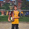 Kayleb joined the competition — help win amazing prizes! child, trophy, medal, sports_uniform, baseball_field, chain_link_fence, sunny_day, blue_sky, grass, dirt, person, victory, pride, spectator, yellow_shirt, black_pants, outdoor, award, celebration, team_sport