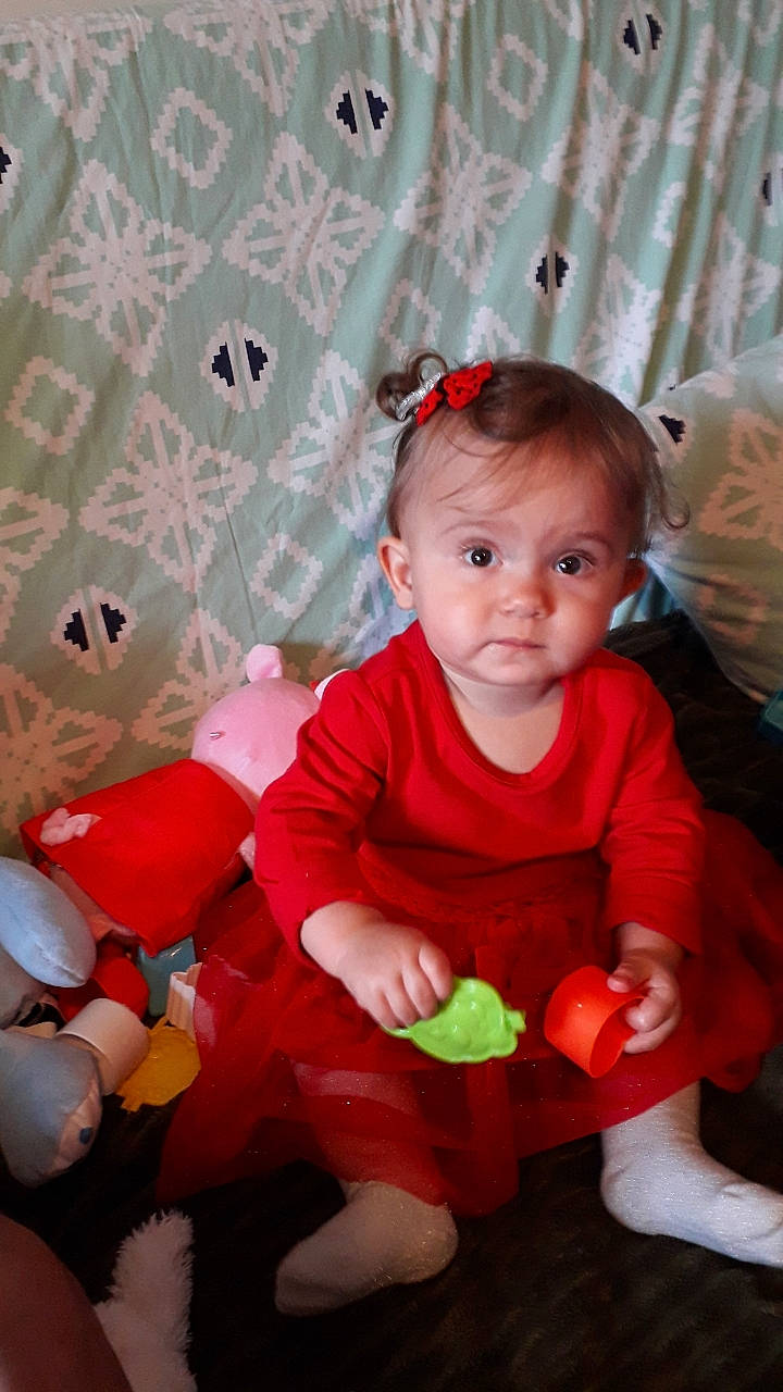 Marianna participe au concours pour gagner de l'argent avec cette photo : baby, baby_playing_with_toys, baby_products, baby_toddler_clothing, cheek, child, event, fun, happy, head, person, pink, product, red, room, sitting, skin, sock, textile, toddler