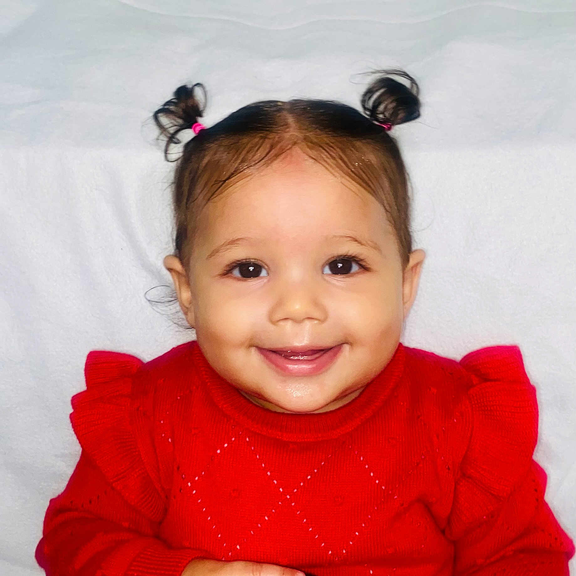 Alianna is registered to the contest to win money with this photo: baby, background, bright, child, clothing, cute, eyes, face, happy, head, indoor, innocence, person, pigtails, portrait, red_sweater, sitting, skin, smile, young_child