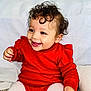 Alianna is registered to the contest to win money with this photo: baby, child, clothing, cozy, curly_hair, cute, face, hand, happy, indoor, infant, joyful, portrait, red_sweater, sitting, smiling, soft_background, toddler, warm, white_tights