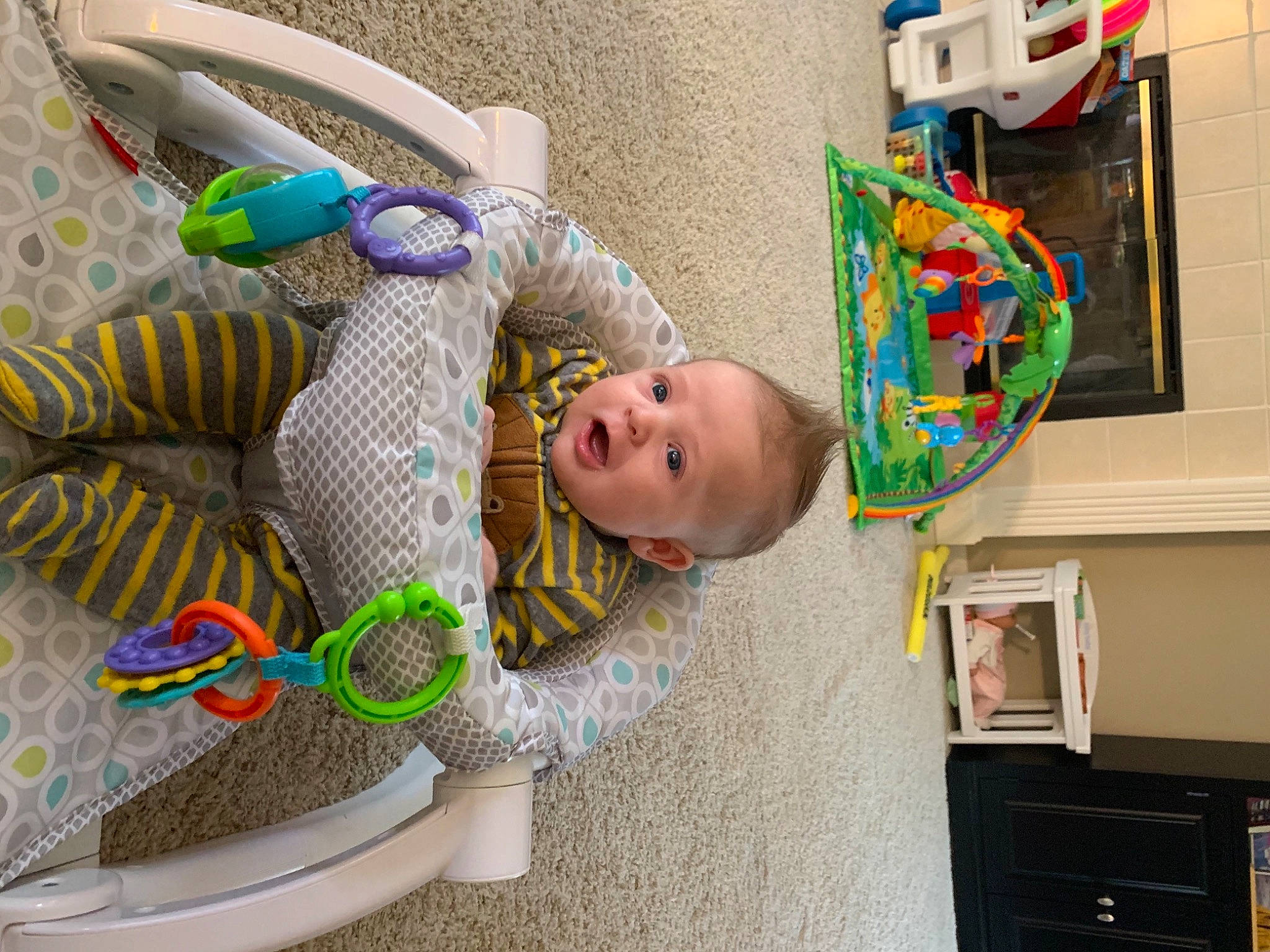 Baker is registered to the contest to win money with this photo: baby, baby_products, baby_toddler_clothing, baby_toys, child, home_appliance, person, plastic, play, product, shelf, stuffed_toy, television, toy