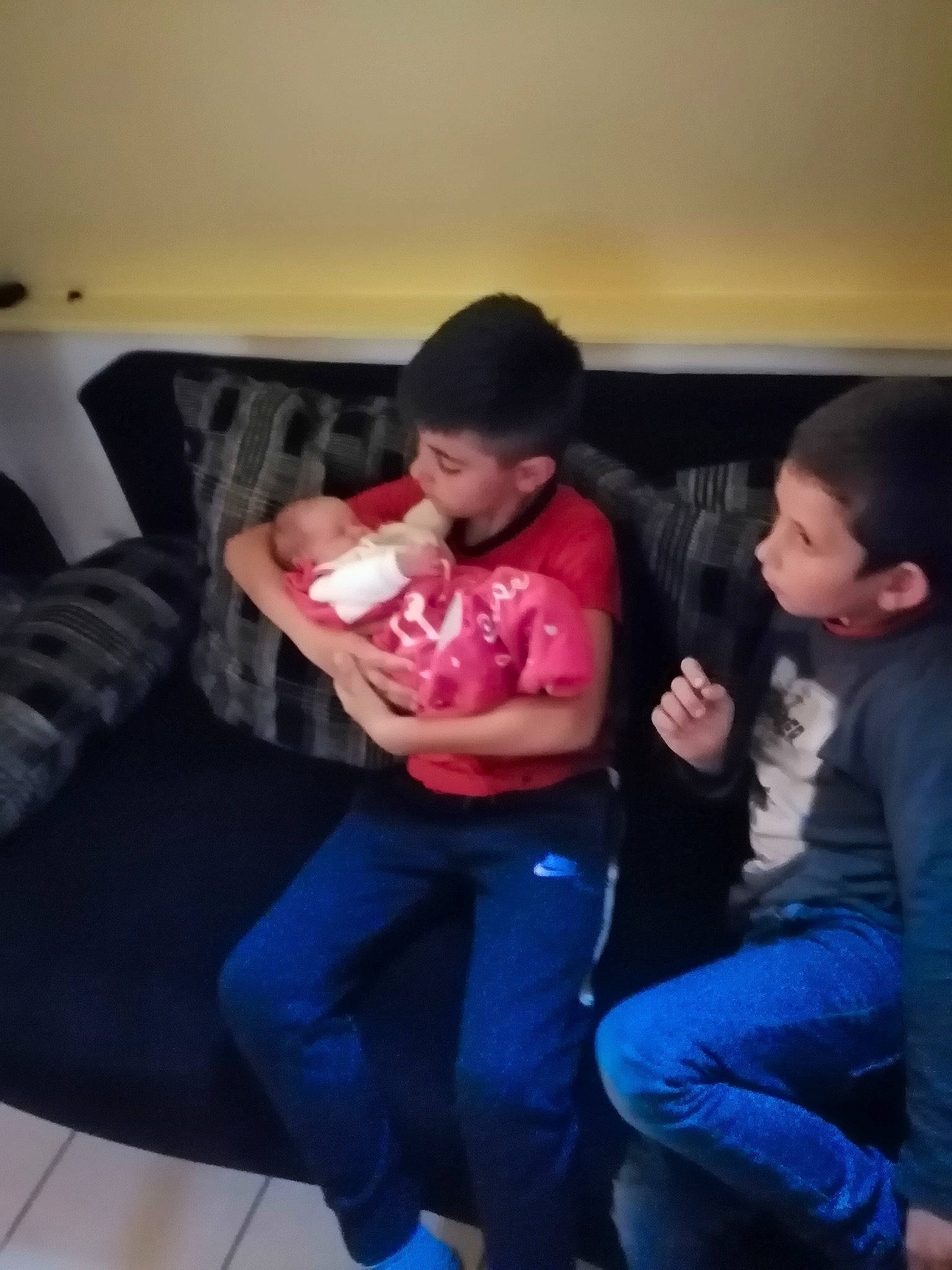 Henzo participe au concours pour gagner de l'argent avec cette photo : arm, child, electronic_device, fun, jeans, leg, mouth, person, sitting, toddler