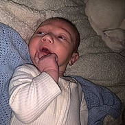 Malachi joined the competition — help win amazing prizes! baby, infant, blanket, blue_blanket, white_clothing, hand, face, person, sleeping_pet, cozy, soft_texture, lying_down, cute, indoors, resting, curious, skin, head, fingers, pet