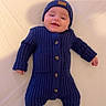Zayone a rejoint le concours — aidez-le/la à gagner de superbes lots ! baby, infant, smiling, blue_outfit, knitwear, hat, onesie, footed_pajamas, lying_down, cozy, warm_clothing, cute, child, portrait, indoors, soft_surface, buttoned, headwear, happy, small_hands