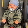 Zayone a rejoint le concours — aidez-le/la à gagner de superbes lots ! baby, infant, car_seat, pacifier, hat, gray_clothing, jacket, pants, socks, seatbelt, child, sitting, indoors, cute, young, person, newborn, warm_clothes, safety, portrait