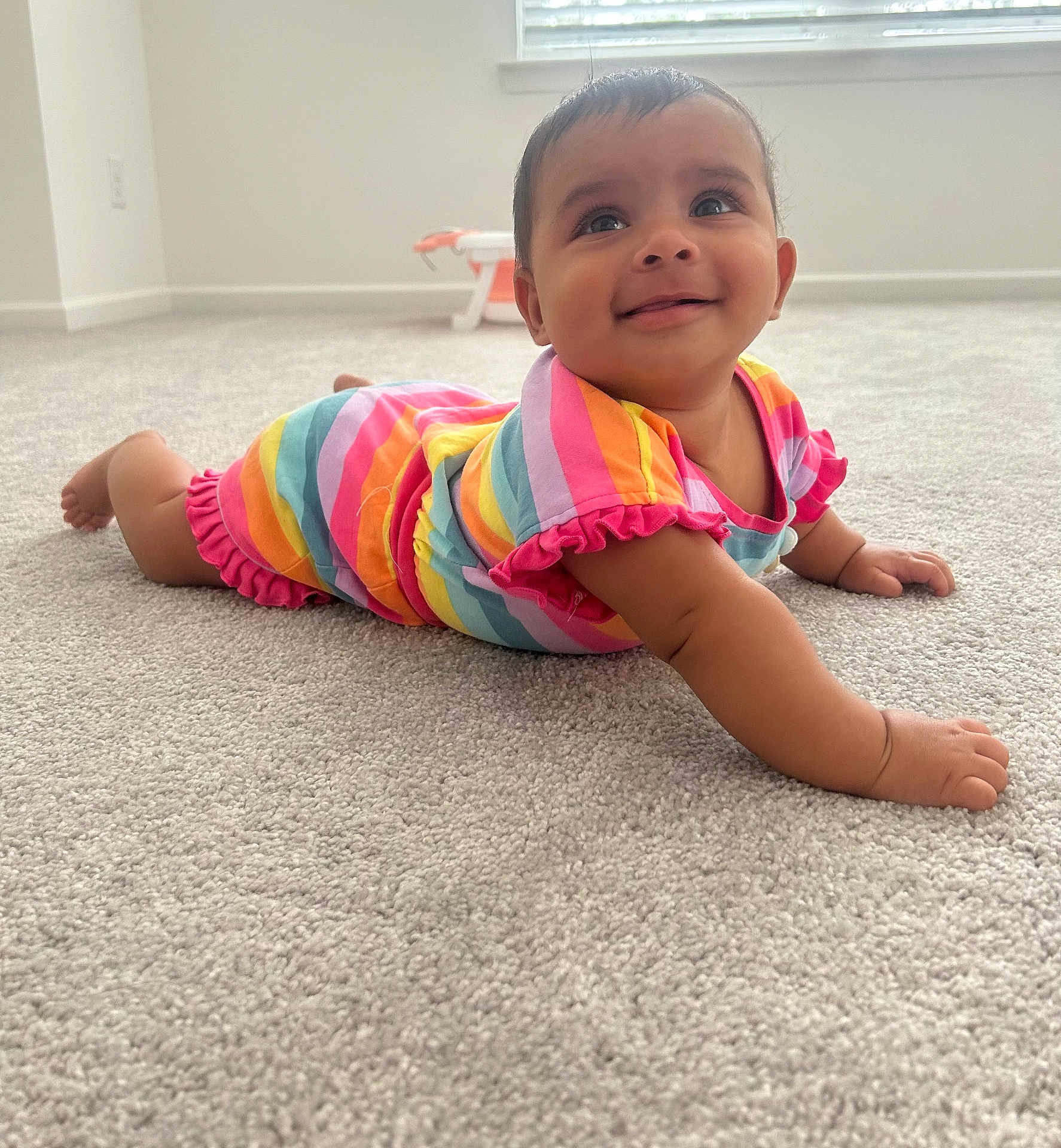 Rudvika joined the competition — help win amazing prizes! baby, infant, child, smiling, rainbow_striped_clothing, carpet, indoor, crawling, cute, happy, person, toddler, bright_colors, playful, room, window, natural_light, skin, face, eyes