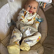 Bobby is registered to the contest to win money with this photo: animal_print, baby, baby_seat, child, comfort, cushion, cute, face, footwear, happy, indoor, infant, onesie, pacifier, playful, plush_toy, relaxing, sleepwear, smile, soft_toy