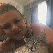 Opal is registered to the contest to win money with this photo: woman, cat, indoor, portrait, relaxed, resting, gray_tabby, shirt, curtains, bedroom, casual, smiling, furniture, human, pet, sleeping_cat, comfort, closeup, face, soft_lighting