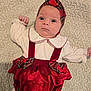 baby, infant, red_velvet, plaid, headband, bows, white_clothing, quilt, texture, lying_down, cute, portrait, indoor, child, face, expression, small_hands, clothing, holiday_outfit, young