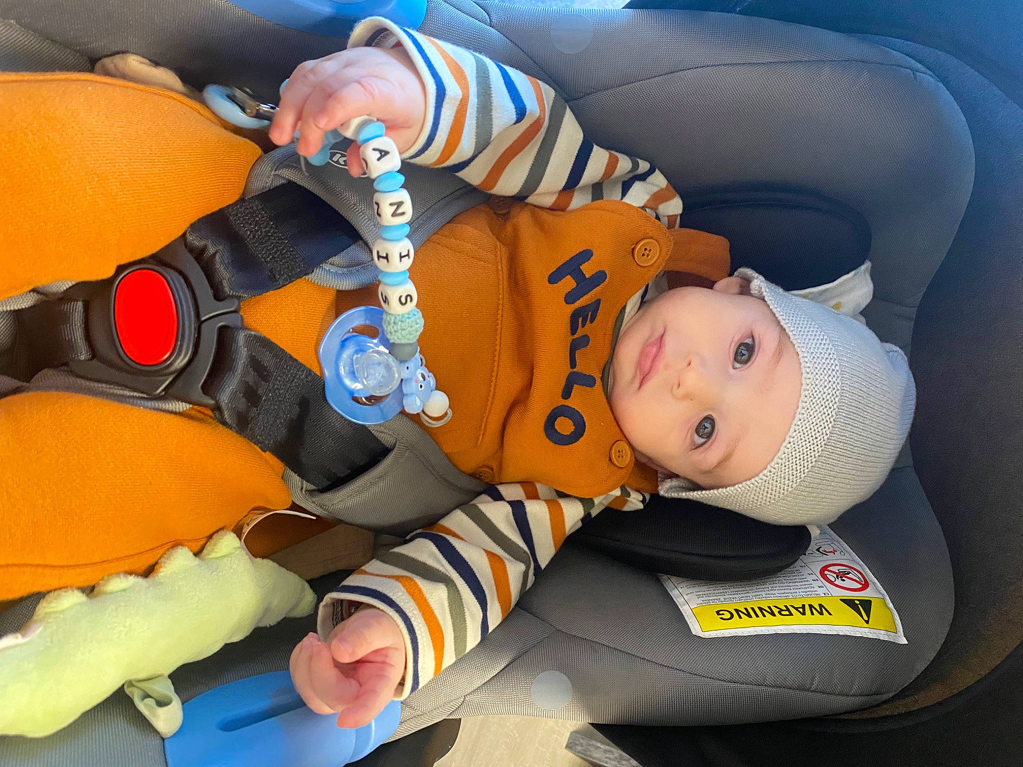 Ianis a rejoint le concours — aidez-le/la à gagner de superbes lots ! auto_part, baby, baby_in_car_seat, baby_products, baby_sleeping, baby_toddler_clothing, bag, car_seat, car_seat_cover, child, comfort, family_car, fun, headwear, lap, leg, orange, person, personal_protective_equipment, sitting