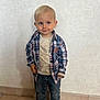 Naël participe au concours pour gagner de l'argent avec cette photo : toddler, child, boy, plaid_shirt, beige_tshirt, denim_jeans, socks, indoor, floor_tiles, wall, standing, smile, cute, portrait, casual_clothing, young_child, person, feet, fashion, candid