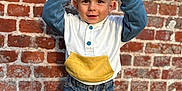 Naël participe au concours pour gagner de l'argent avec cette photo : toddler, child, brick_wall, jeans, sneakers, hoodie, smiling, outdoor, standing, hands_up, cute, blond_hair, casual_clothing, portrait, daylight, happy, playful, young_child, person, fashion