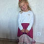 child, girl, red_bow, white_shirt, red_skirt, backpack, floral_pattern, indoor, tile_floor, wall, power_outlet, smile, standing, holding, portrait, young, cute, casual_clothing, happy, person