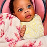 Kailani is registered to the contest to win money with this photo: baby, infant, blanket, pink, red, cushion, seat, curly_hair, face, eyes, hand, clothing, yellow, soft_texture, portrait, indoor, child, cute, expression, cozy