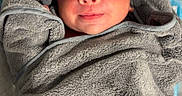 Liam joined the competition — help win amazing prizes! baby, infant, towel, hooded_towel, gray, wrapped, cute, face, eyes, smile, bed, blanket, soft, newborn, child, indoors, portrait, sleepy, cozy, person