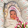 baby, infant, blanket, polka_dots, tulips, flowers, bouquet, text, pink_text, cushion, patterned, pacifier, headwrap, wrapped, cute, adorable, lying_down, celebration, gift, love