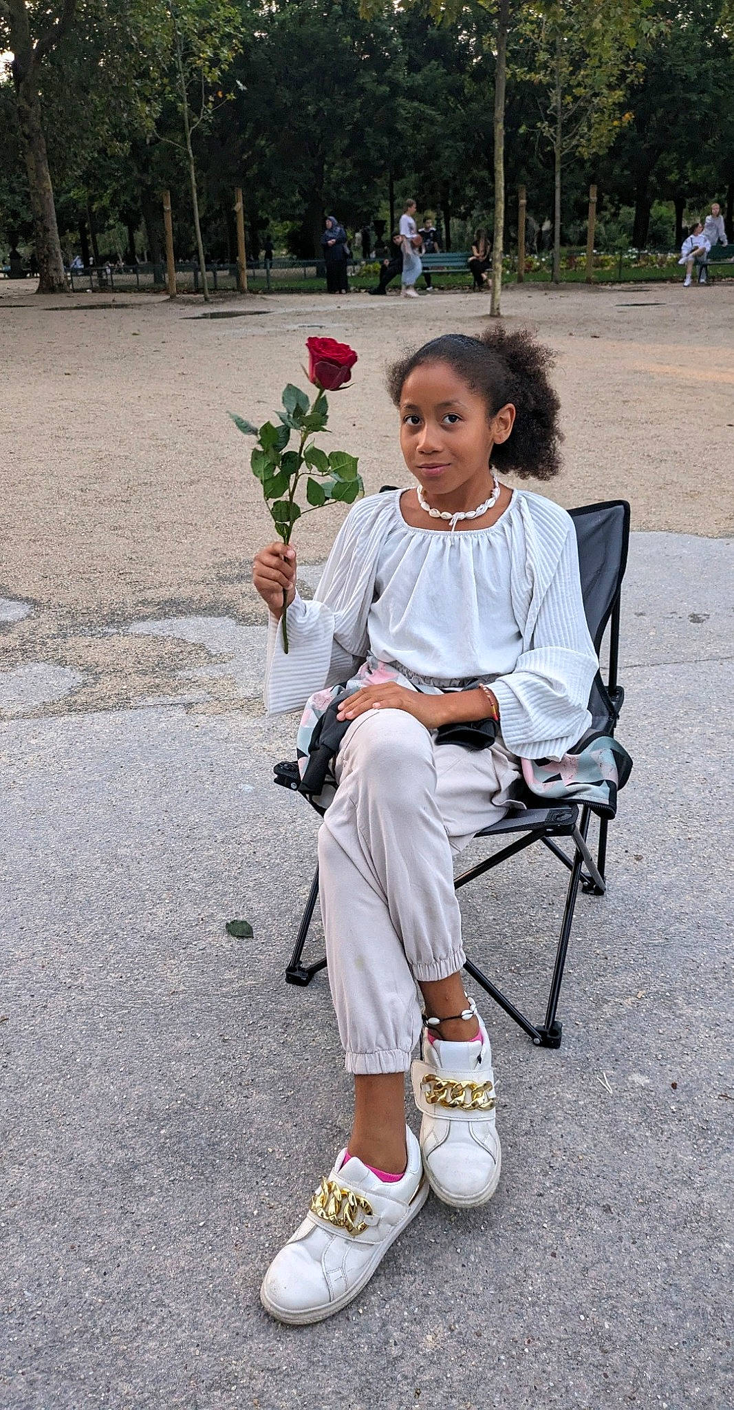 Kaylliah a rejoint le concours — aidez-le/la à gagner de superbes lots ! asphalt, child, event, fashion_accessory, flower, fun, grass, human_leg, joy, leisure, person, plant, recreation, road, road_surface, sandal, sidewalk, sitting, street, tree