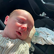 Carter joined the competition — help win amazing prizes! newborn, baby, sleeping, face, hand, car_interior, clothing, infant, skin, peaceful, sunlight, closeup, portrait, person, seat, blanket, bottle, soft_light, rest, human