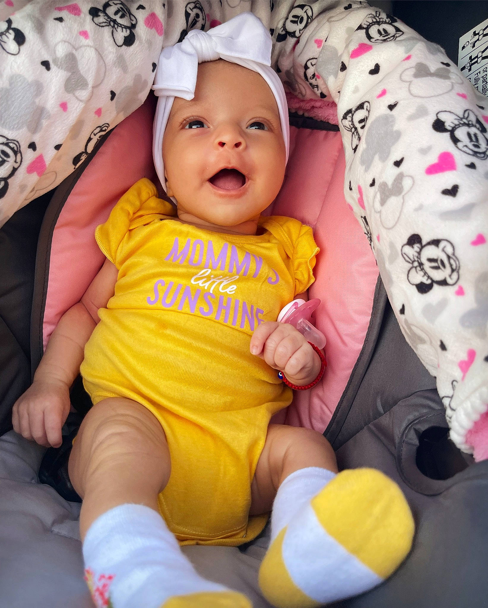 Sonia is registered to the contest to win money with this photo: baby, baby_toddler_clothing, cheek, comfort, eye, face, finger, happy, headgear, headwear, lap, leg, mouth, person, pink, skin, sleeve, smile, t_shirt, thigh