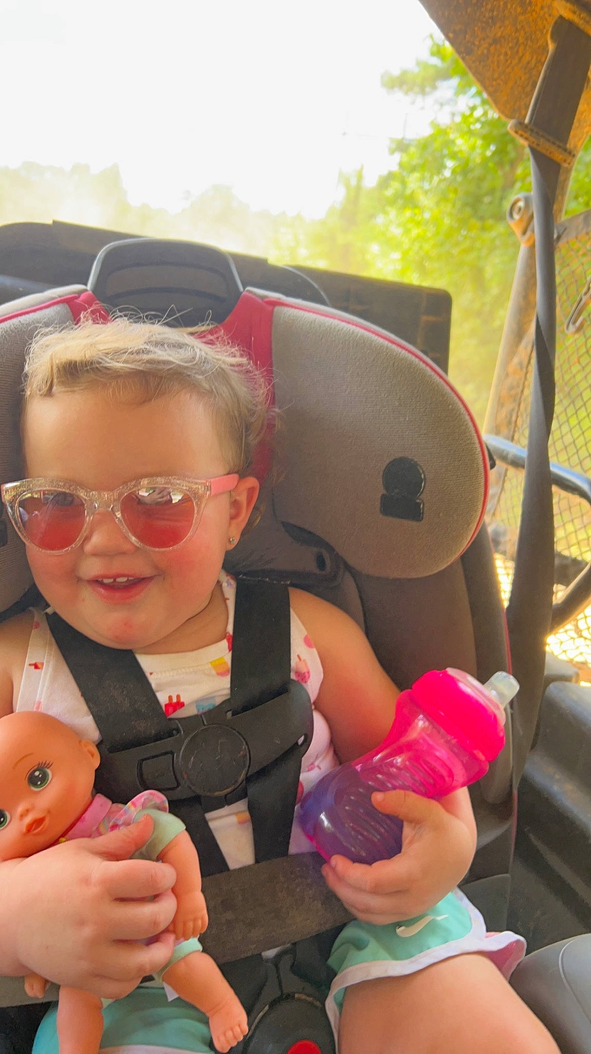 Olivia is registered to the contest to win money with this photo: baby, child, eyewear, family_car, fun, glasses, goggles, happy, joy, leisure, person, personal_protective_equipment, pink, recreation, skin, sky, sunglasses, thumb, toddler, toy
