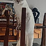 Queen participe au concours pour gagner de l'argent avec cette photo : artwork, blue_eyes, cabinet, cat, closeup, curious, dining_table, furniture, home_interior, indoor, kitten, paws, playful, portrait, sculpture, standing, vertical_photo, whiskers, wooden_chair, woven_seat