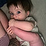 Kinzley is registered to the contest to win money with this photo: baby, child, foot, hand, tattoo, skin, blue_eyes, bed, blanket, person, closeup, cute, infant, playful, casual, indoor, relaxed, young, human, comfort