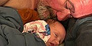 Alana is registered to the contest to win money with this photo: man, baby, tattoo, blanket, sleeping, bed, closeup, face, resting, cozy, intimate, cuddling, newborn, portrait, indoor, comfort, family, skin, gray_hair, love