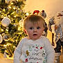 Theo is registered to the contest to win money with this photo: baby, celebration, child, christmas, cute, decoration, face, festive, holiday, holiday_spirit, indoors, lights, onesie, ornaments, portrait, santa, seasonal, smiling, tree, winter