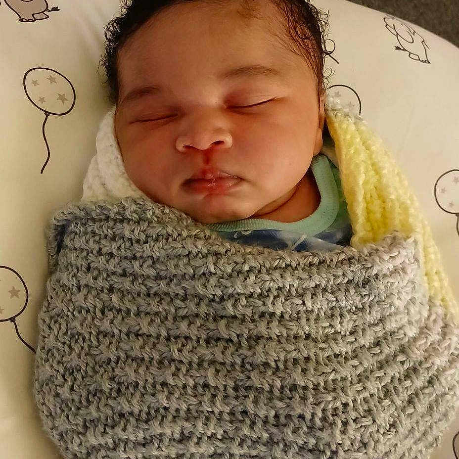 Nasir is registered to the contest to win money with this photo: baby, blanket, clothing, cushion, face, head, homedecor, newborn, person, photography, portrait, scarf, sleeping
