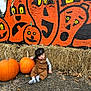 Wesley is registered to the contest to win money with this photo: child, toddler, pumpkin, hay, fall, autumn, outdoor, orange, overalls, cap, ground, leaves, mural, painting, face_paint, smile, cute, seasonal, decoration, festival