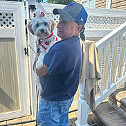Honey joined the competition — help win amazing prizes! backyard, cap, casual_clothing, daylight, dog, fence, flower, holding, jeans, leash, man, outdoor, pavement, pet, portrait, residential, smile, stairs, sunlight, white_dog