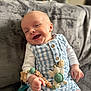 Mylan a rejoint le concours — aidez-le/la à gagner de superbes lots ! baby, infant, smiling, blue_checkered_romper, crocheted_toy, wooden_beads, pacifier_clip, gray_blanket, happy, cute, child, indoor, portrait, handmade_toy, soft_texture, relaxed, small_hands, sitting, cozy, playful