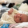 Mylan a rejoint le concours — aidez-le/la à gagner de superbes lots ! baby, infant, lying_down, bed, blanket, clothing, pacifier, face, cozy, smile, closeup, soft_focus, indoor, cute, newborn, person, sleeve, hand, head, expression