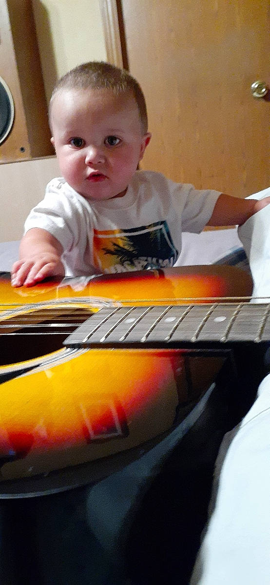 Roman is registered to the contest to win money with this photo: acoustic_guitar, child, guitar, music, musical_instrument, musical_instrument_accessory, musician, person, play, plucked_string_instruments, sitting, slide_guitar, string_instrument, toddler