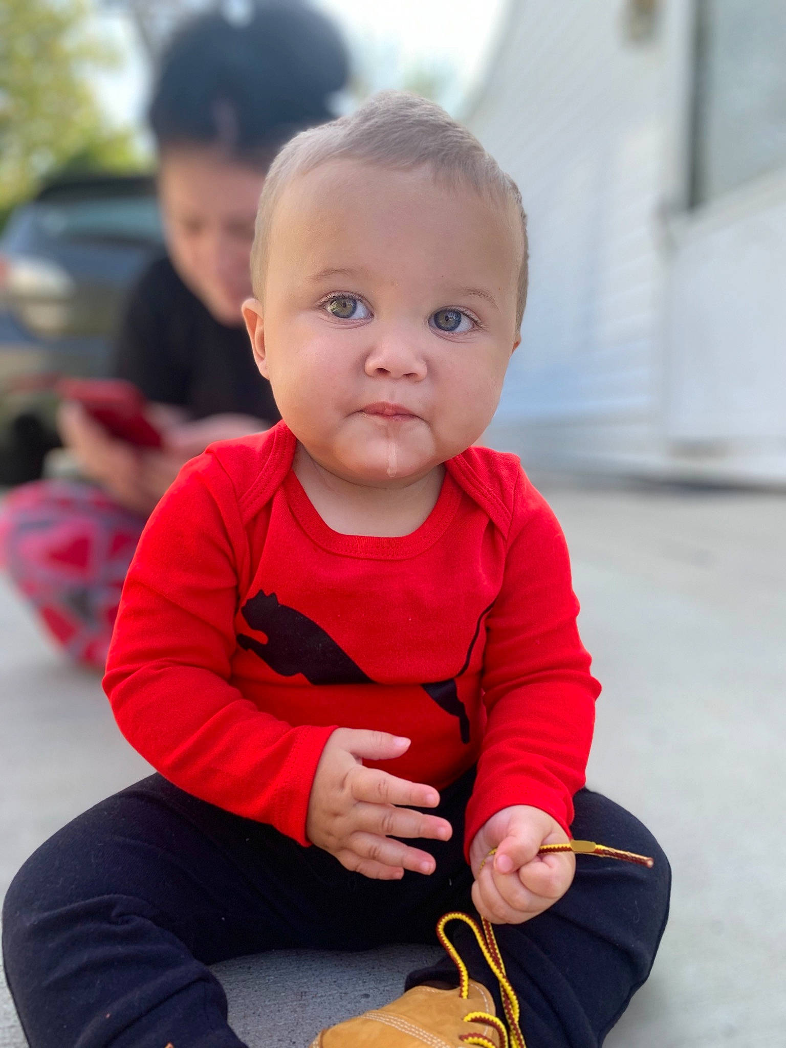 Roman is registered to the contest to win money with this photo: arm, baby, cheek, child, child_model, outerwear, person, play, red, sitting, skin, sleeve, smile, toddler